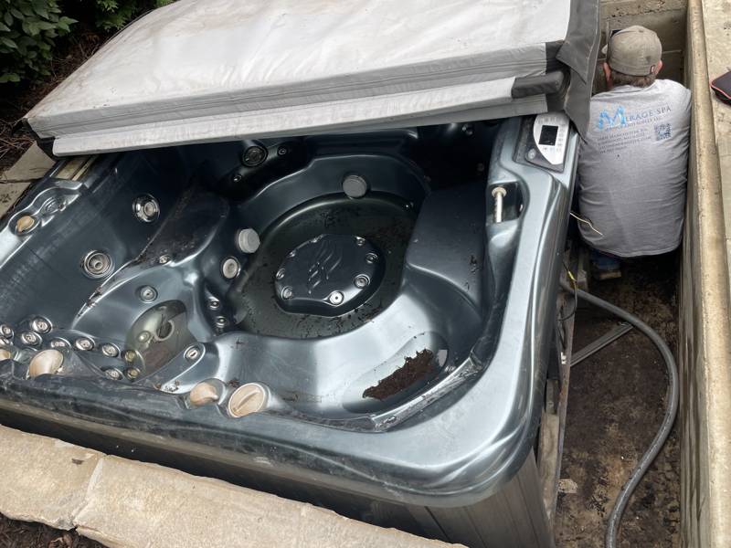 Mirage Spa technician servicing an in-ground hot tub at a home in the St. Louis area